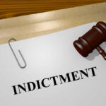 Gavel on a white paper with the word indictment on it.