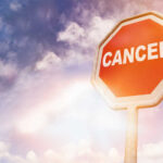 Trump Aide’s Cancer News Stuns D.C. A stop sign with the word 'CANCER' against a cloudy sky