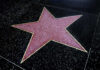 A red star embedded in a black sidewalk, part of the Hollywood Walk of Fame