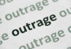 Close-up of the word 'outrage' printed in bold on paper