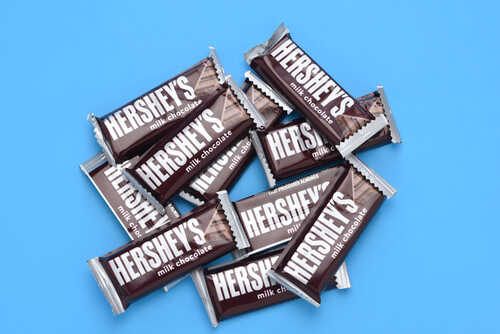 A pile of Hershey's milk chocolate bars on a blue background