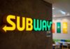 Illuminated Subway restaurant sign with green and yellow colors