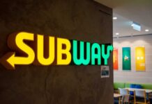 Illuminated Subway restaurant sign with green and yellow colors
