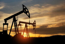 Oil pump jacks silhouetted against sunrise sky