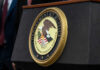 Department of Justice seal on a podium.