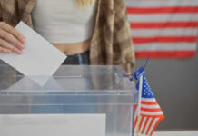 Person casting vote into a ballot box.