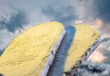 Two stone tablets with inscriptions against a cloudy sky