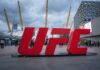 Large red UFC sign in front of a busy outdoor venue