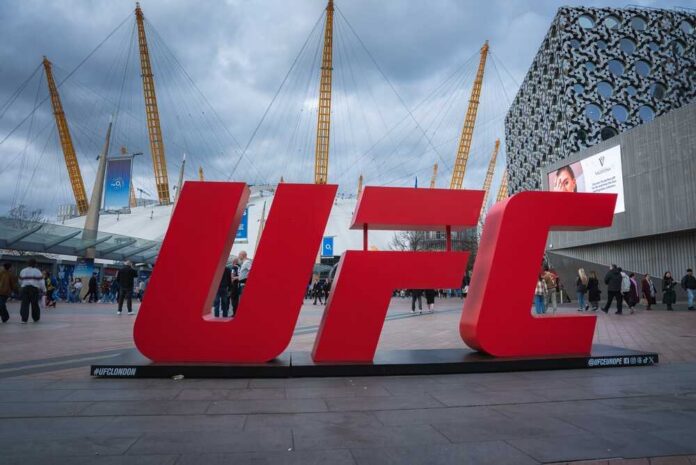 shutterstock_2614241281.jpg Large red UFC sign in front of a busy outdoor venue