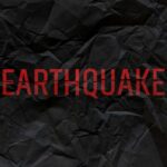 Crumpled black paper with the word 'EARTHQUAKE' in bold red letters