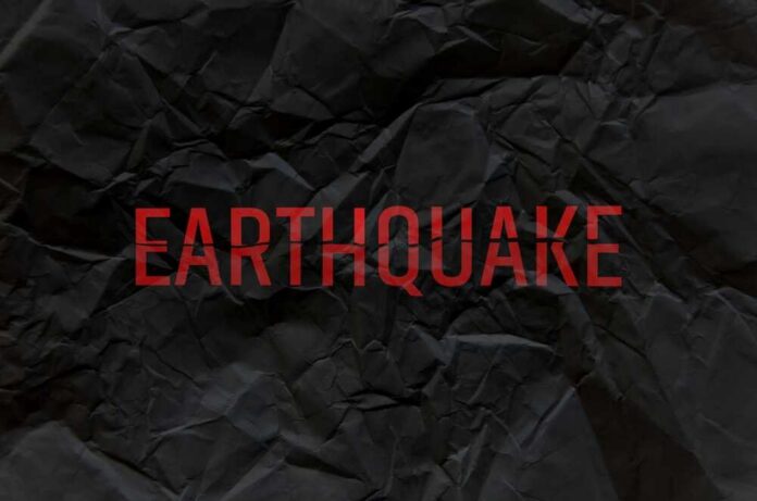 Crumpled black paper with the word 'EARTHQUAKE' in bold red letters
