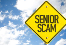 Yellow warning sign displaying 'SENIOR SCAM' against a blue sky