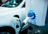 Electric Car Flops: Fans Fuming! Electric vehicle charging at a station, close-up view.