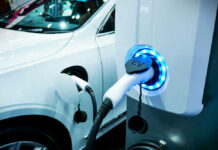 Electric vehicle charging at a station, close-up view.