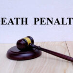 FedEx Driver To Be EXECUTED for Christmas Delivery Murder A wooden gavel resting on a block with the words 'DEATH PENALTY' in bold above it