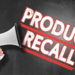 RECALL ALERT: Three Blinded — Millions At Risk Megaphone and Product Recall text on chalkboard.