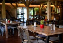 Interior of a cozy restaurant with wooden tables and decorative plants
