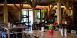 Interior of a cozy restaurant with wooden tables and decorative plants