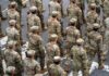 A formation of soldiers in military uniforms marching in a parade
