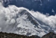 Avalanche Horror: American Climber’s Fatal Plunge Snow-covered mountain peak partially obscured by clouds