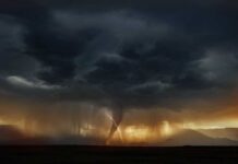 A dramatic storm with dark clouds and a lightning strike over mountains