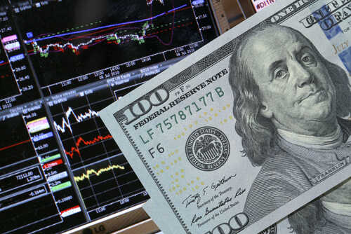 Stock,Market,Graph,With,Dollars,Banknote A close-up of a hundred-dollar bill in front of stock market graphs