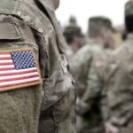 Appeals Court Attacks Pentagon Ban U.S. soldiers in camouflage uniforms with American flag patch.