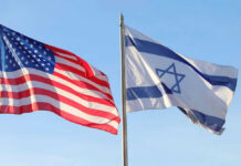 American and Israeli flags waving against a clear sky.