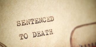 Close-up of a typewritten document stating 'SENTENCED TO DEATH'
