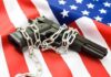A handgun wrapped in chains on an American flag