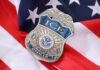 Outsider Tapped To Run ICE ICE officer badge resting on an American flag