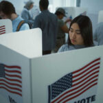 Trump Power Play In Georgia — Senate Control At Risk People voting in booths with American flags.