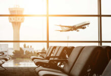 Airline Backlash Explodes Over THIS Rule? View of an airport terminal with an airplane taking off in the background