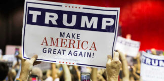 People holding Trump Make America Great Again signs.