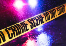 Ambush Took Life of Deputy U.S. Marshal Crime scene tape with flashing lights in background.