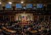 Armed Visits Push Justices Into Congress A crowded congressional chamber with members gathered around the central podium