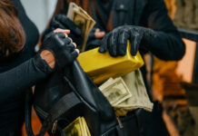 Scam Factories Print Billions — Modern Slavery Inside Individuals in black clothing stealing money and items
