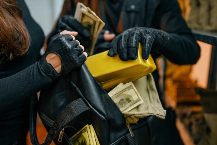 Individuals in black clothing stealing money and items