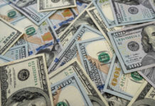 Billionaire Cash Bomb Hits 25 Million Kids Scattered hundred dollar bills with Benjamin Franklins portrait.