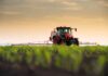 ALERT: Spike Wipes Out Farming Profits A tractor spraying crops in a field during sunset