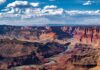 Power Cliff Looms at Glen Canyon A panoramic view of the Grand Canyon with a river winding through the landscape