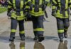 Wildfire Tragedy Takes Another Heroic Firefighter Three firefighters walking in uniform on a wet surface