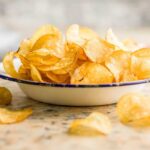 FDA’s HIGHEST Alert Hits Popular Chips A bowl filled with golden, crispy potato chips on a countertop