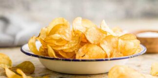 A bowl filled with golden, crispy potato chips on a countertop