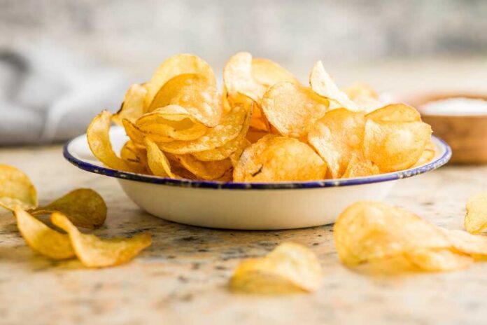 A bowl filled with golden, crispy potato chips on a countertop