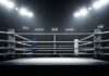 An empty boxing ring illuminated by bright lights in a sports arena