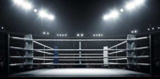 An empty boxing ring illuminated by bright lights in a sports arena