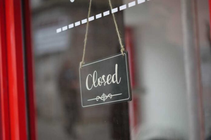 Closed,Sign,Hanging,On,A,Cafe,Door,During,Business,Hours A closed sign hanging on a shop window