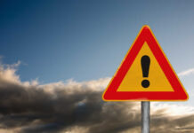 VIDEO: Mall Blast Horror Grips Country A triangular warning sign with an exclamation mark against a cloudy sky
