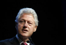 Clinton’s July Fourth Grenade Lands Man with gray hair speaking at an event.